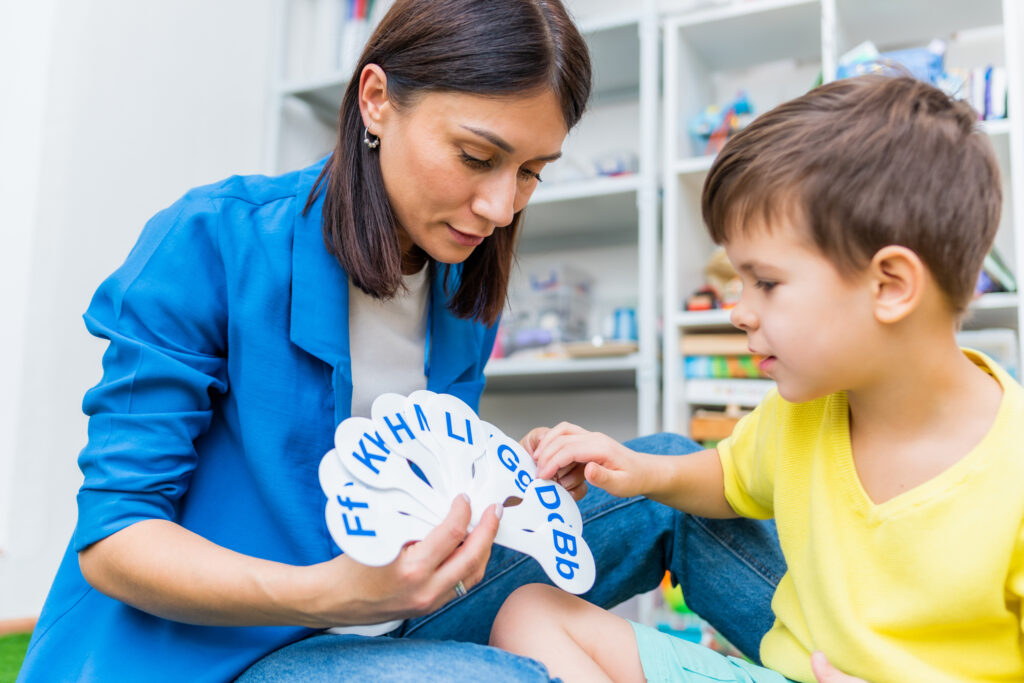 A child with a speech therapist is taught to pronounce the letters, words and sounds correctly.
