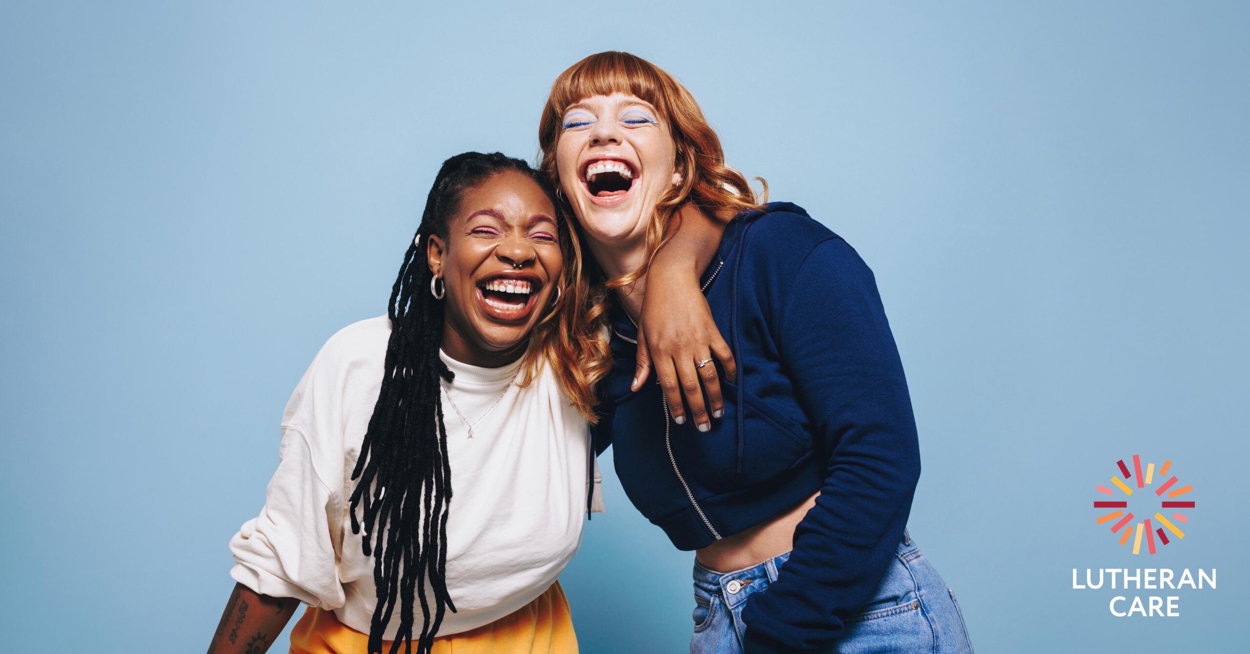 Two women laugh together. The Lutheran Care logo appears in the bottom right hand corner.