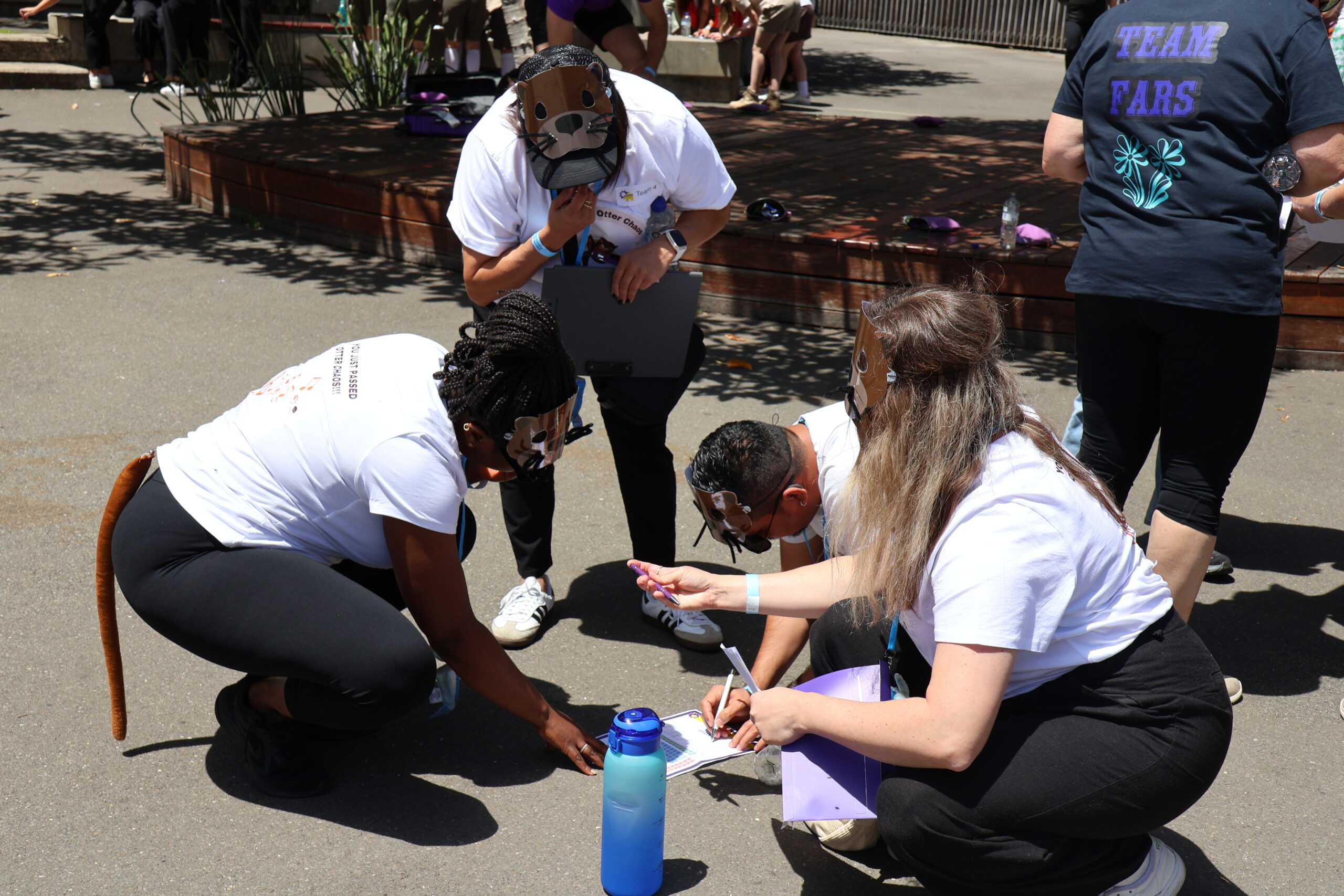 Staff discussing a clue during The Amazing Race activity at the All Staff Day