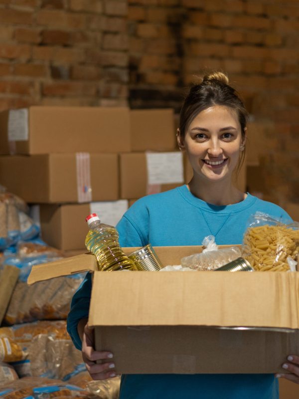 Volunteer preparing donation food boxes for people.